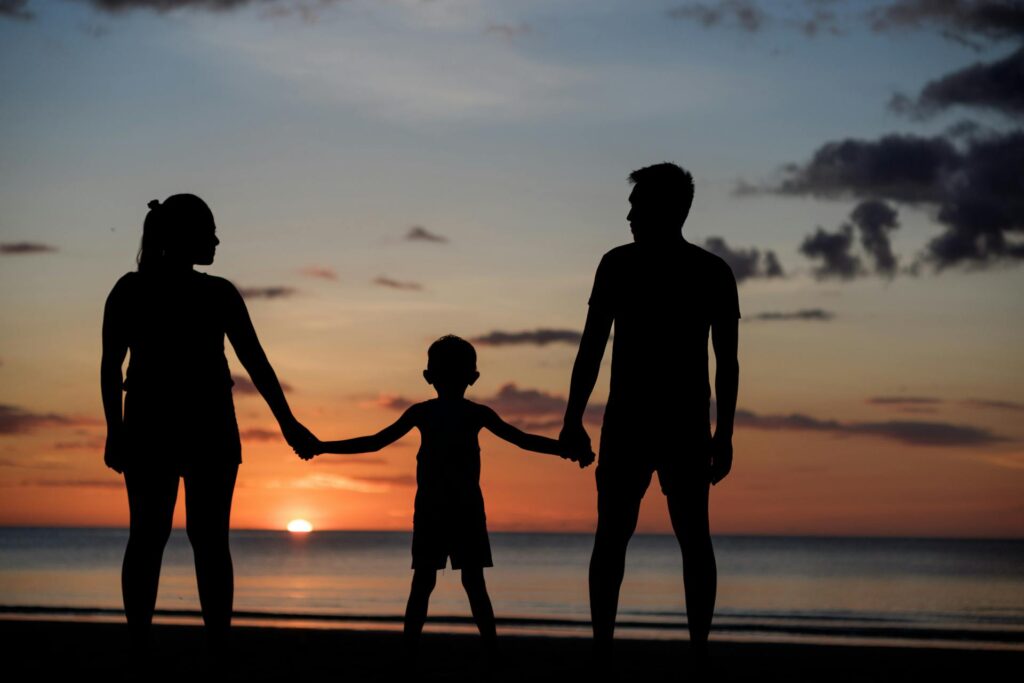 silhouette of a family holding hands during the sunset while on a Destin family vacation