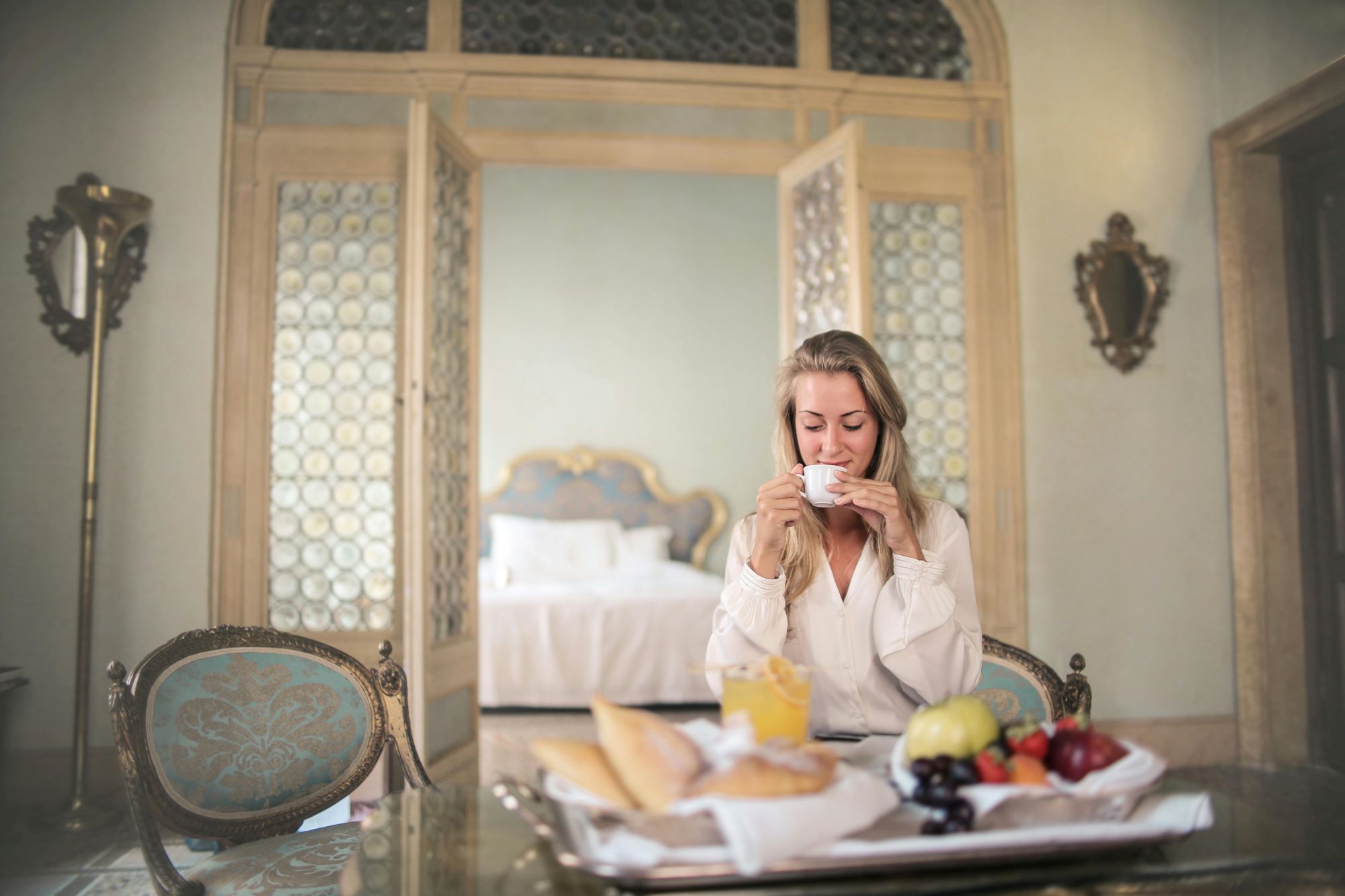 a woman sitting at a table with a tray of food and a cup of coffee