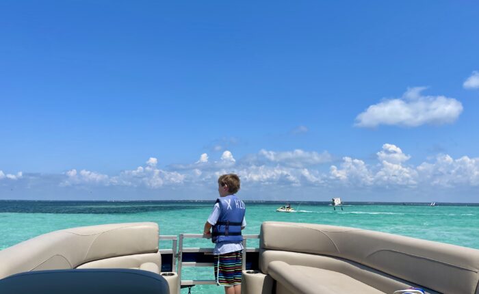 a boy standing on a boat