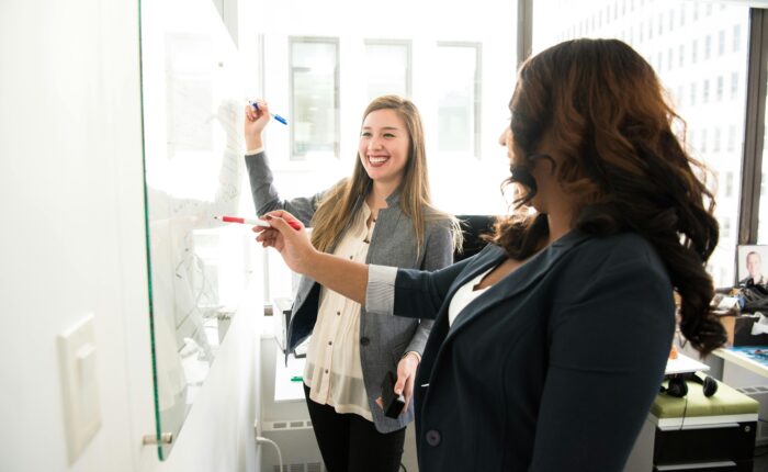 a woman writing on a whiteboard