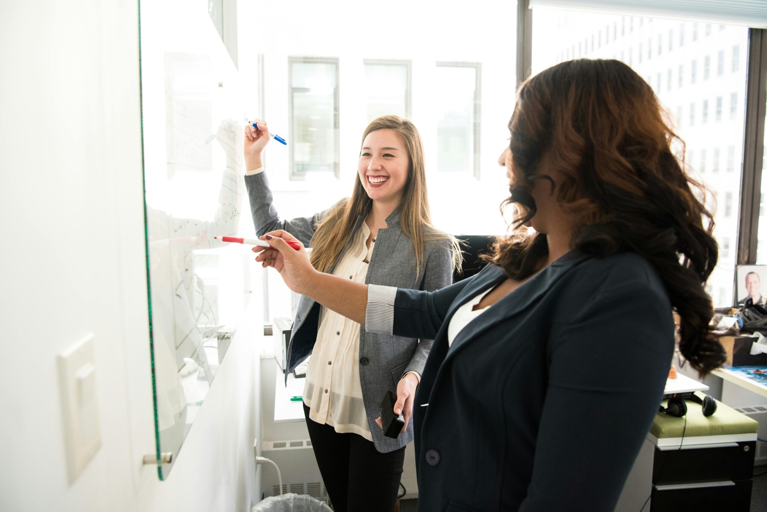 a woman writing on a whiteboard