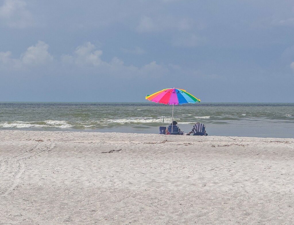 a beach with a colorful umbrella