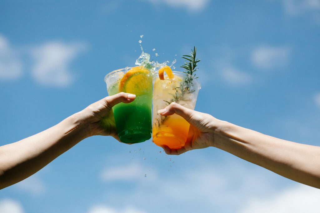 two drinks being held by two people who are toasting their drinks