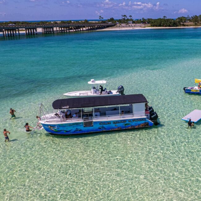 The Crab Island Runner tour boat anchored at Crab Island with swimmers around it